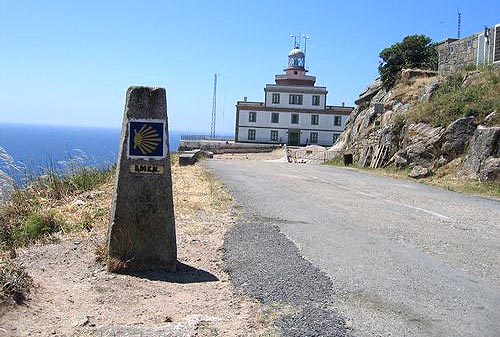 de vuurtoren op de Kaap Finisterre met links de eindwegwijzer van de Camino