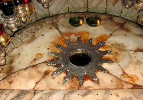 14-puntige zilveren ster op marmer, die de geboorteplaats van Jezus aanduidt. Bethlehem, Geboortekerk. 