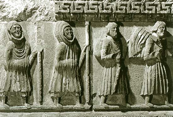 pelgrims in winterkledij om de bergen over te steken. Romaans reliëf, 12de eeuw.Fidenza, San Donnino kathedraal