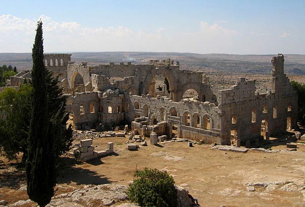 Runes van de basiliek van de H. Simeon de Styliet. Ernaast zijn de resten van het oudst bewaard gebleven gasthuis voor pelgrims. Deir Seman (nabij Aleppo, in Noord-Syri).