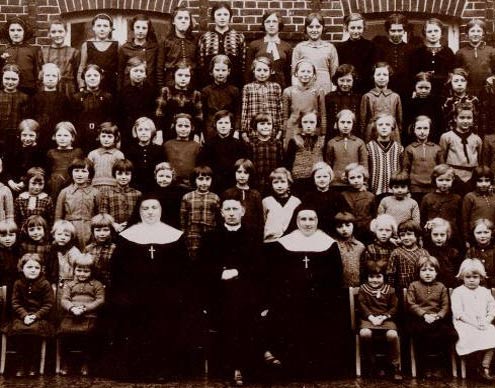 Schoolfoto. Midden vooraan, vlnr, Alg. Overste Maes, pastoor Faict en Zr Pelagie (1939)